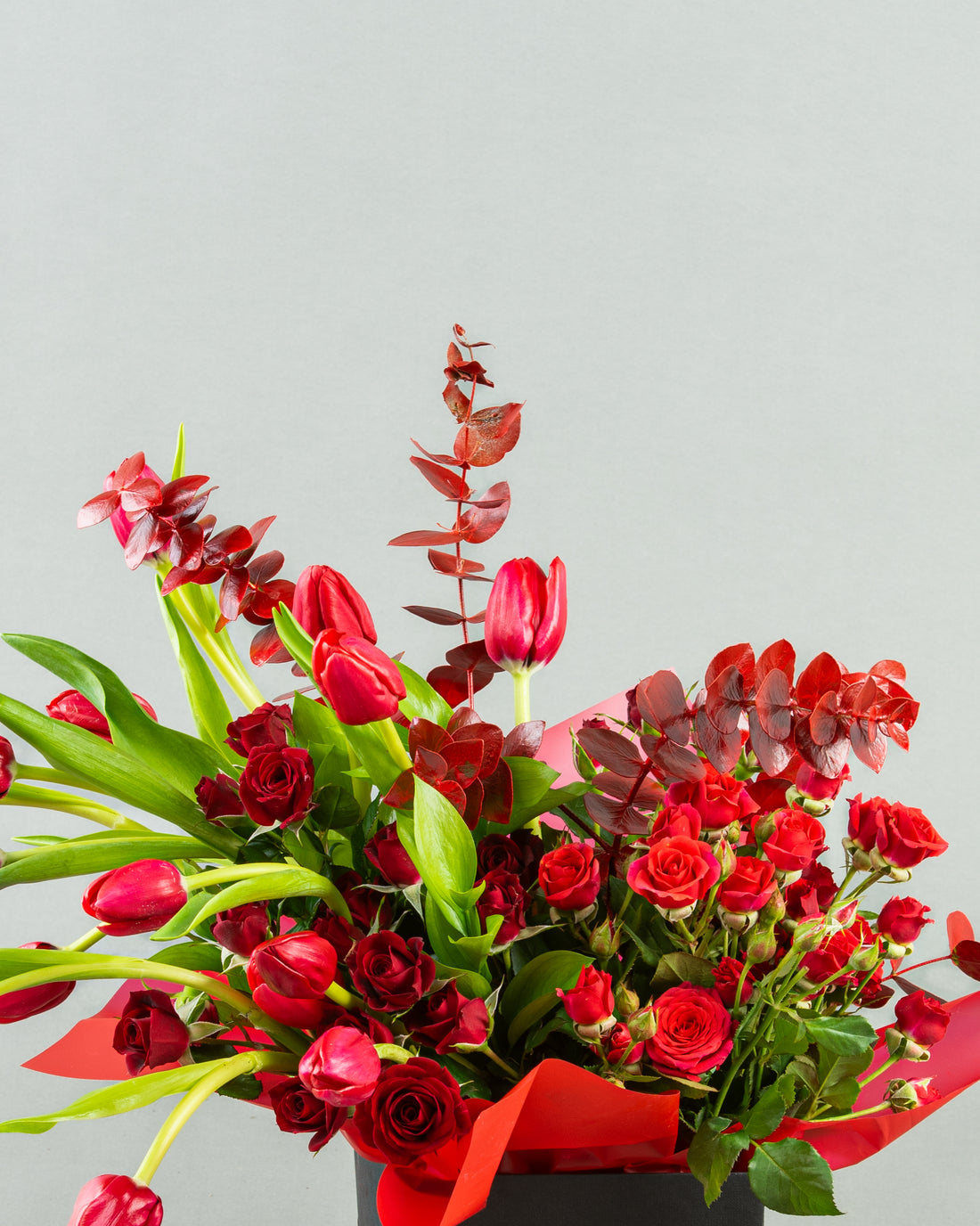 Crimson Elegance: Red Tulips and Baby Roses with Red Eucalyptus