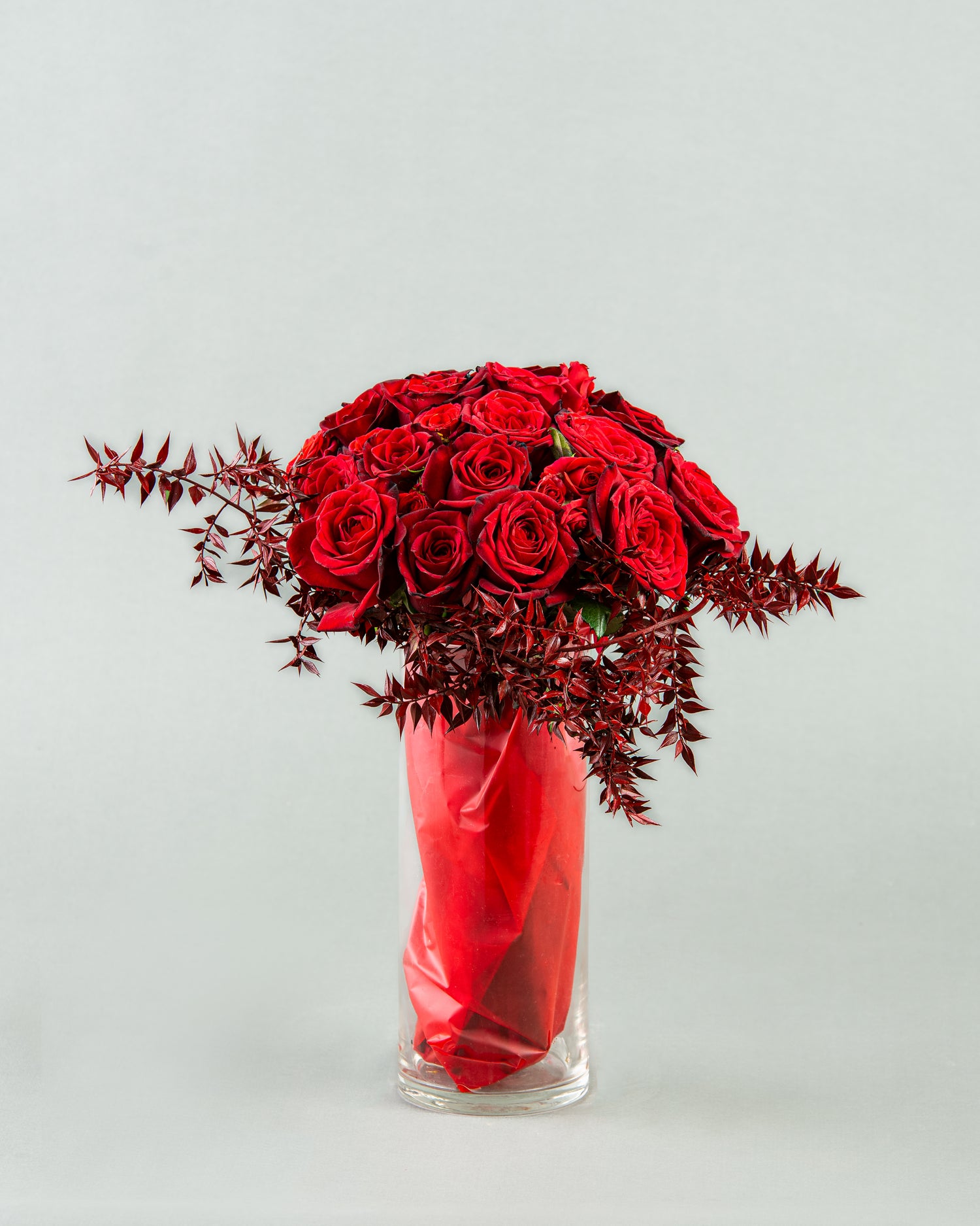 Crimson Elegance: 20 Red Roses with Bordo Ruscus in Vase