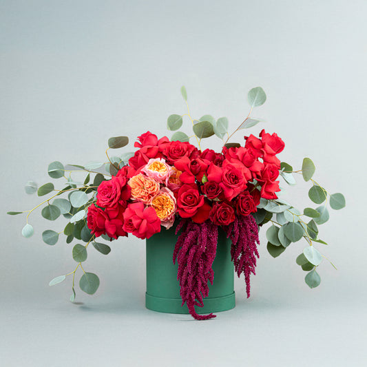 A Sophisticated Arrangement Red Roses with Eucalyptus, English Roses, and Amaranthus in Green Cylindrical Box