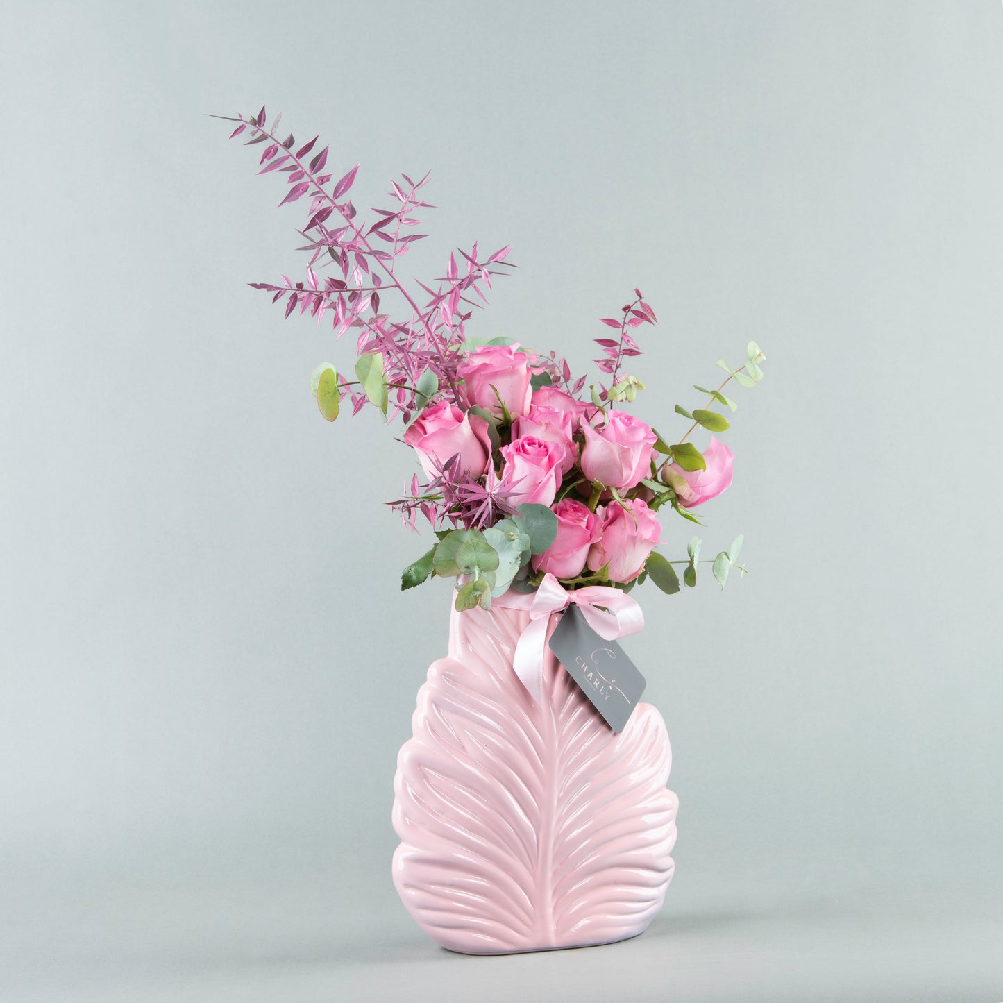 Whimsical Foliage: Fuchsia Roses in Pink Leaf-Shaped Vase