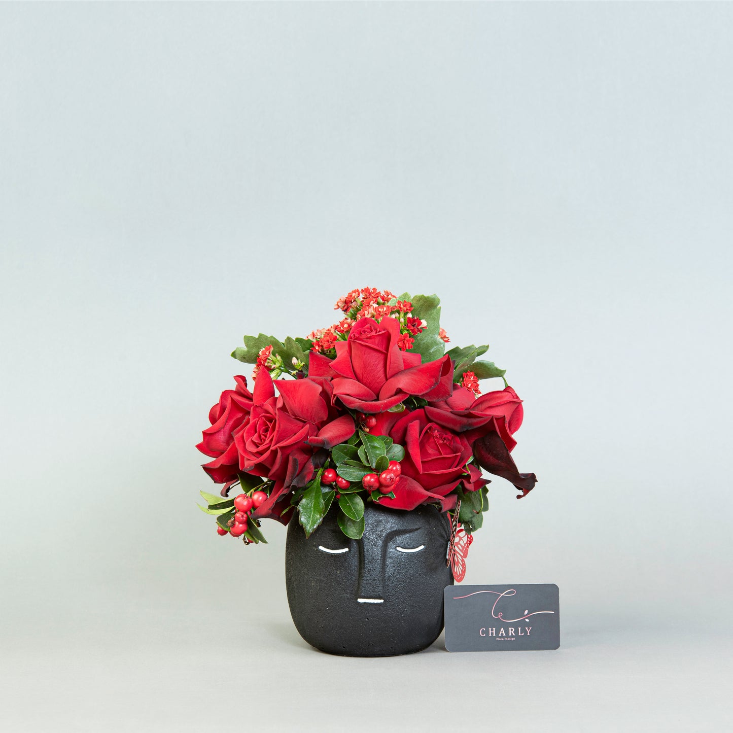 Enigmatic Beauty: Red Roses with Wild Berries in Black Face Pot