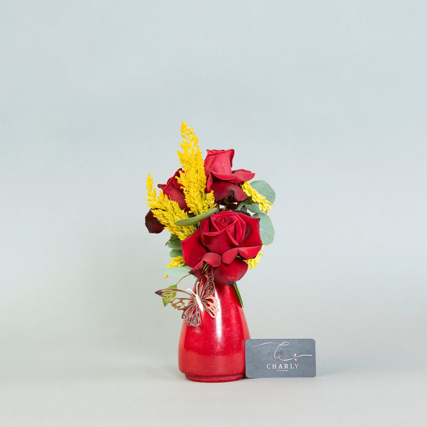 Crimson Essence: Red Roses and Eucalyptus in Terrazzo Vase