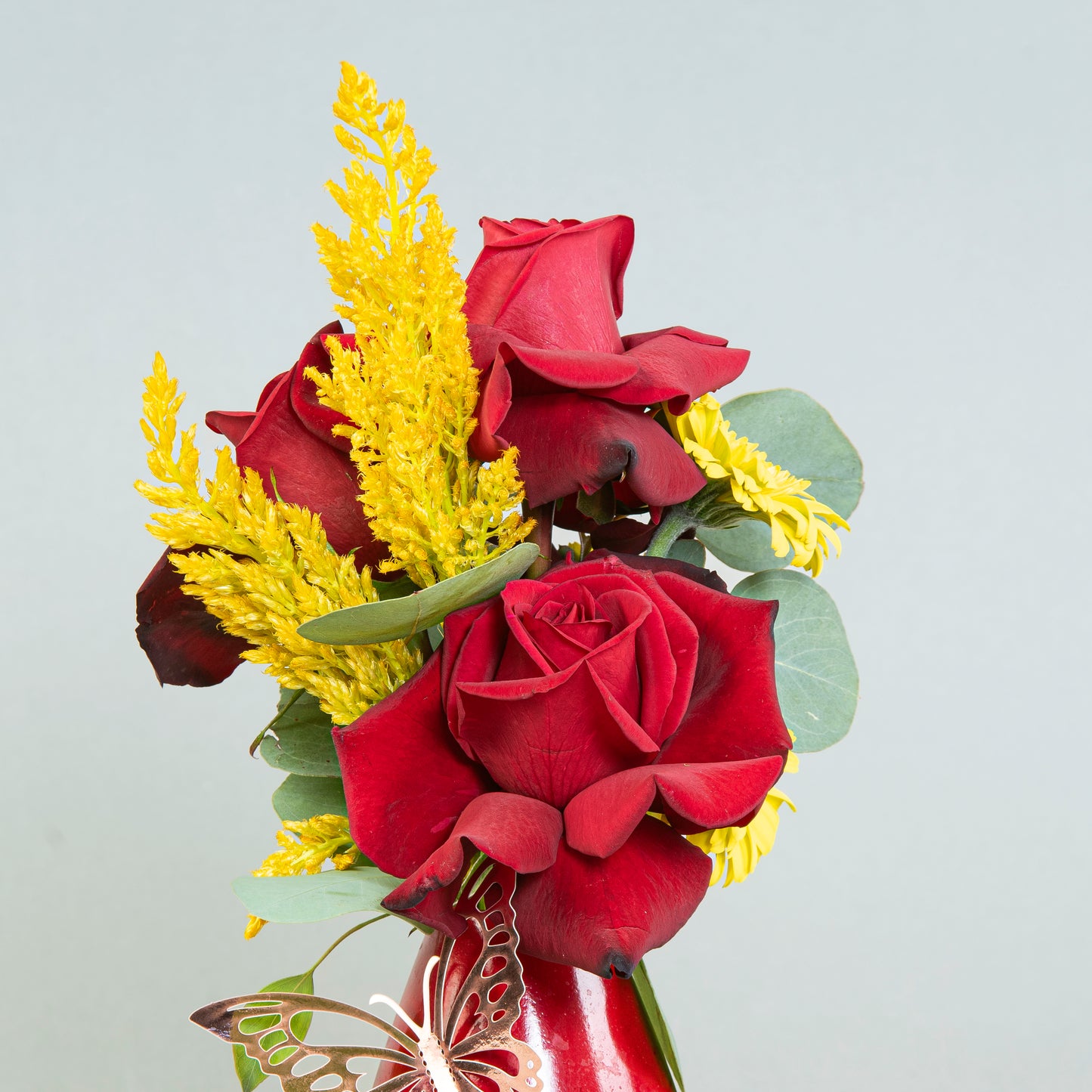 Crimson Essence: Red Roses and Eucalyptus in Terrazzo Vase