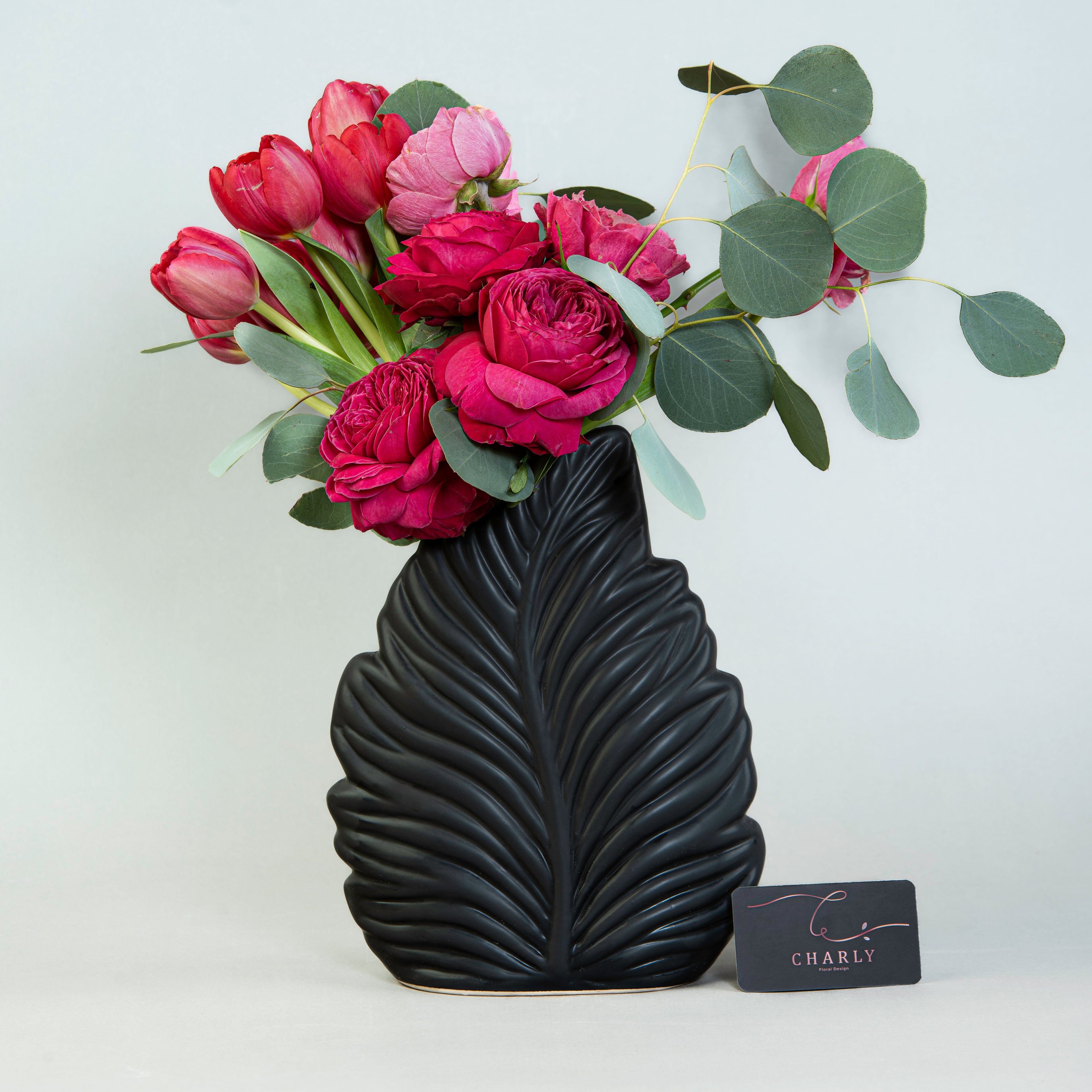 Crimson Flora Elegance: Red Tulips and Roses in Leaf-Shaped Vase